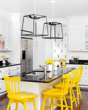 Vibrant yellow chairs in a black & white kitchen